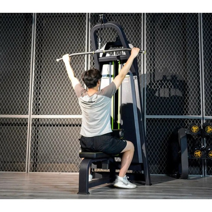 Lat mašina crno-žute boje sa weight stack-om od 100 kg, profesionalna sprava za jačanje leđa.